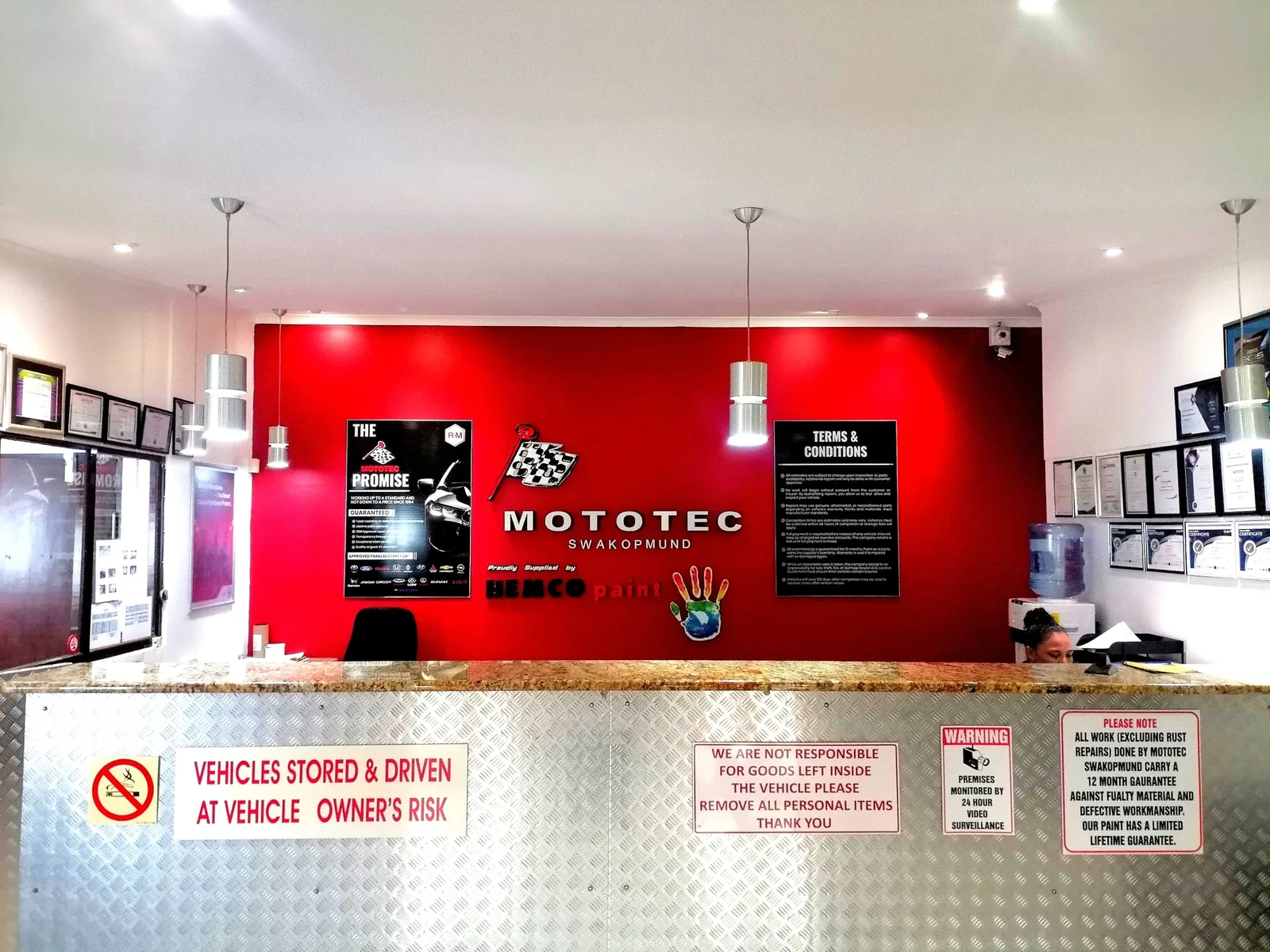 Mototec Swakopmund reception counter in front of the red branded wall