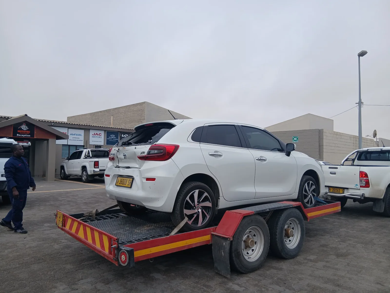 White hatchback on a recovery trailer in the Mototec yard